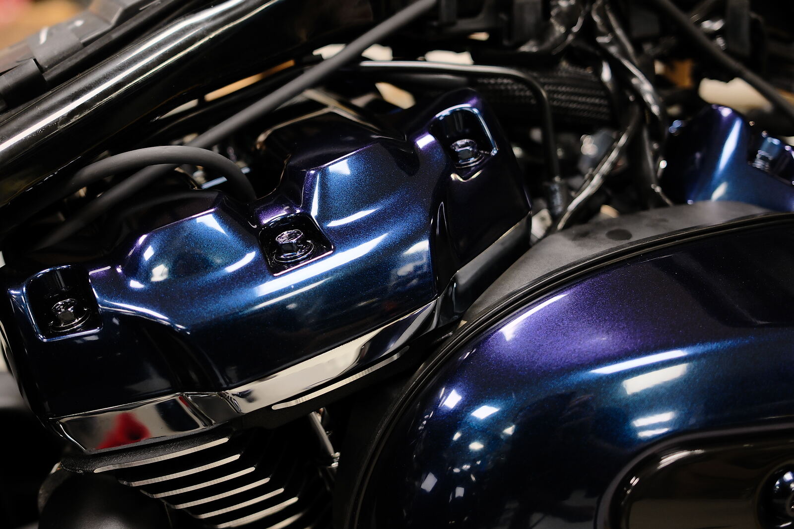 Ventildeckel und Tank einer Harley im gleichen Chamäleon-Ton, die Deckel wirken blau, der Tank violett