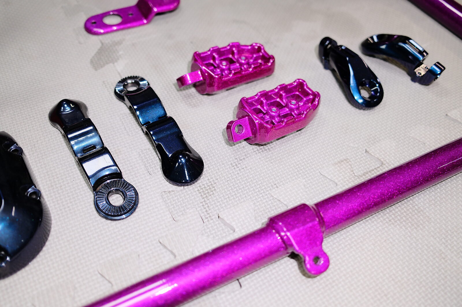 Fussrasten und Bolzen in Magenta, dazwischen Motordeckel in einem Chamäleon-Ton