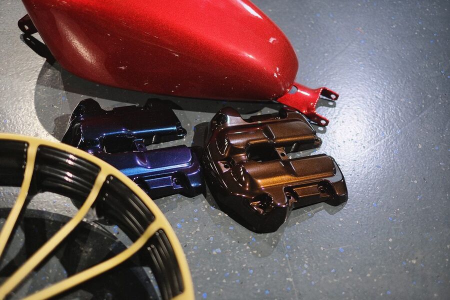 Roter Metallic-Tank mit beschichteten Ventildeckeln und einem Rad im Vordergrund
