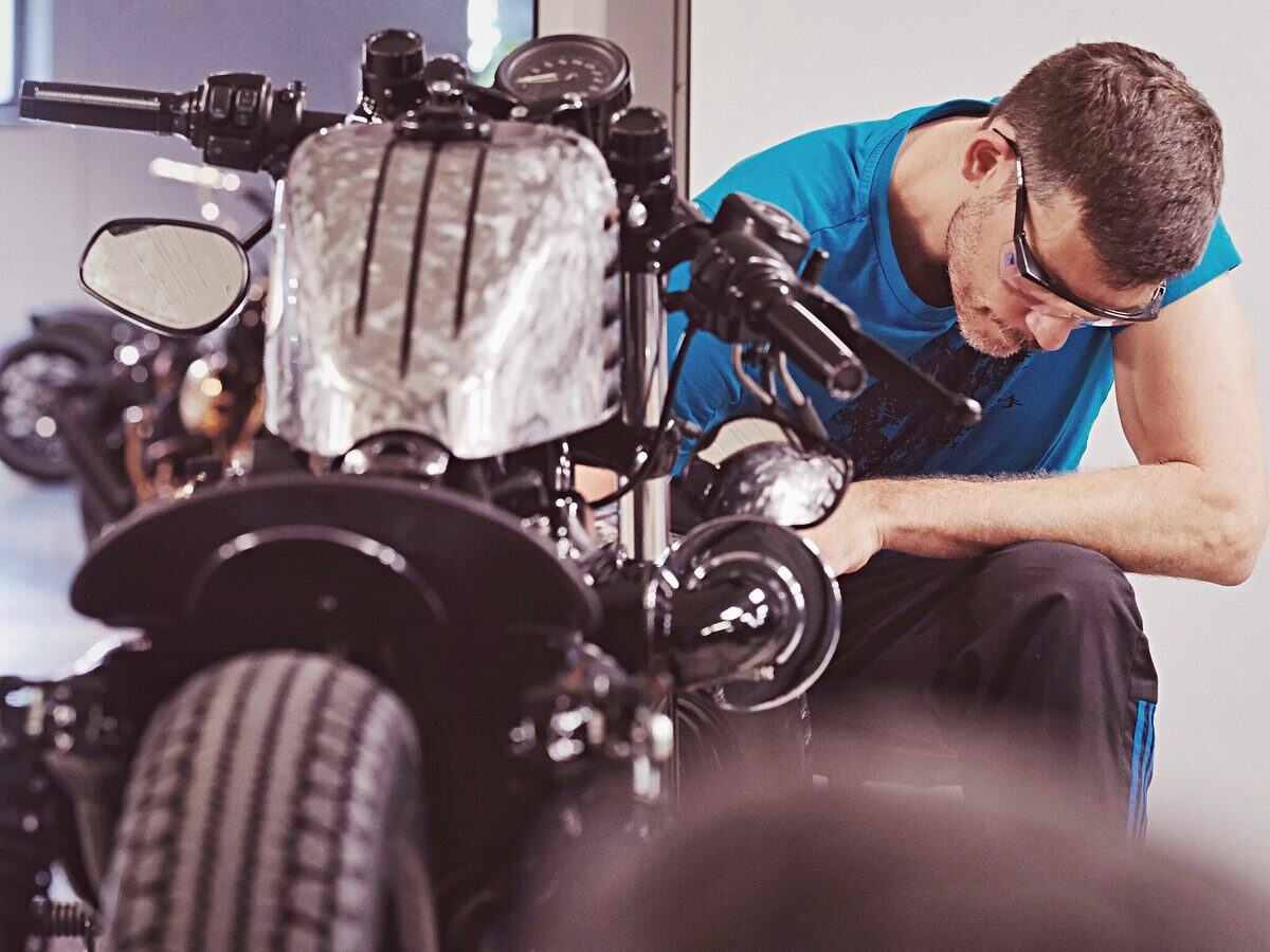 Mechaniker bei der Arbeit an einem umgebauten Motorrad auf der Hebebühne