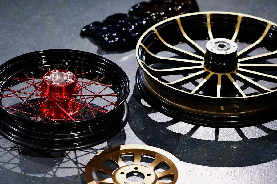 Zwei Motorradräder, ein Bremssattel und eine Bremsscheibe in vier verschiedenen Farben