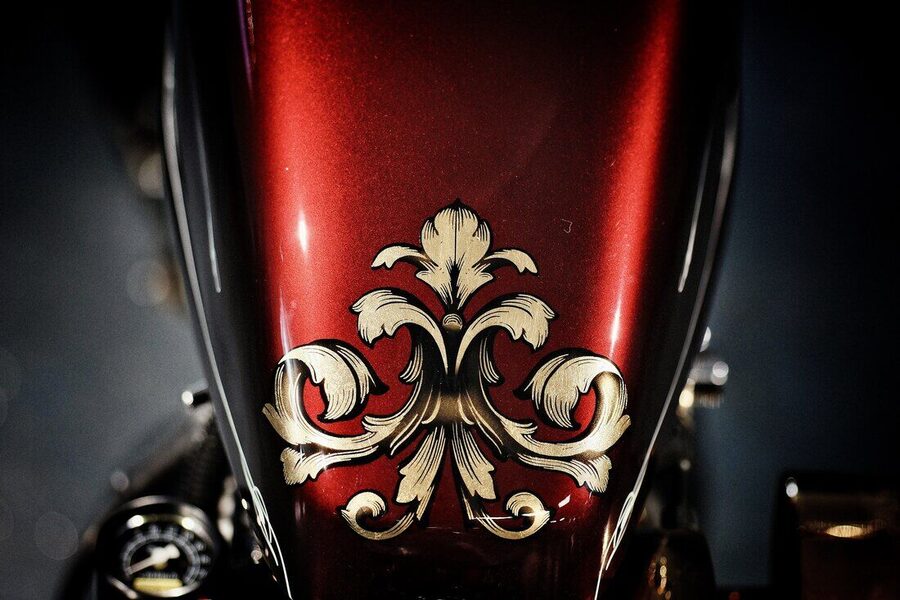 Roter Motorradtank mit goldenem Ornament in Handmalerei