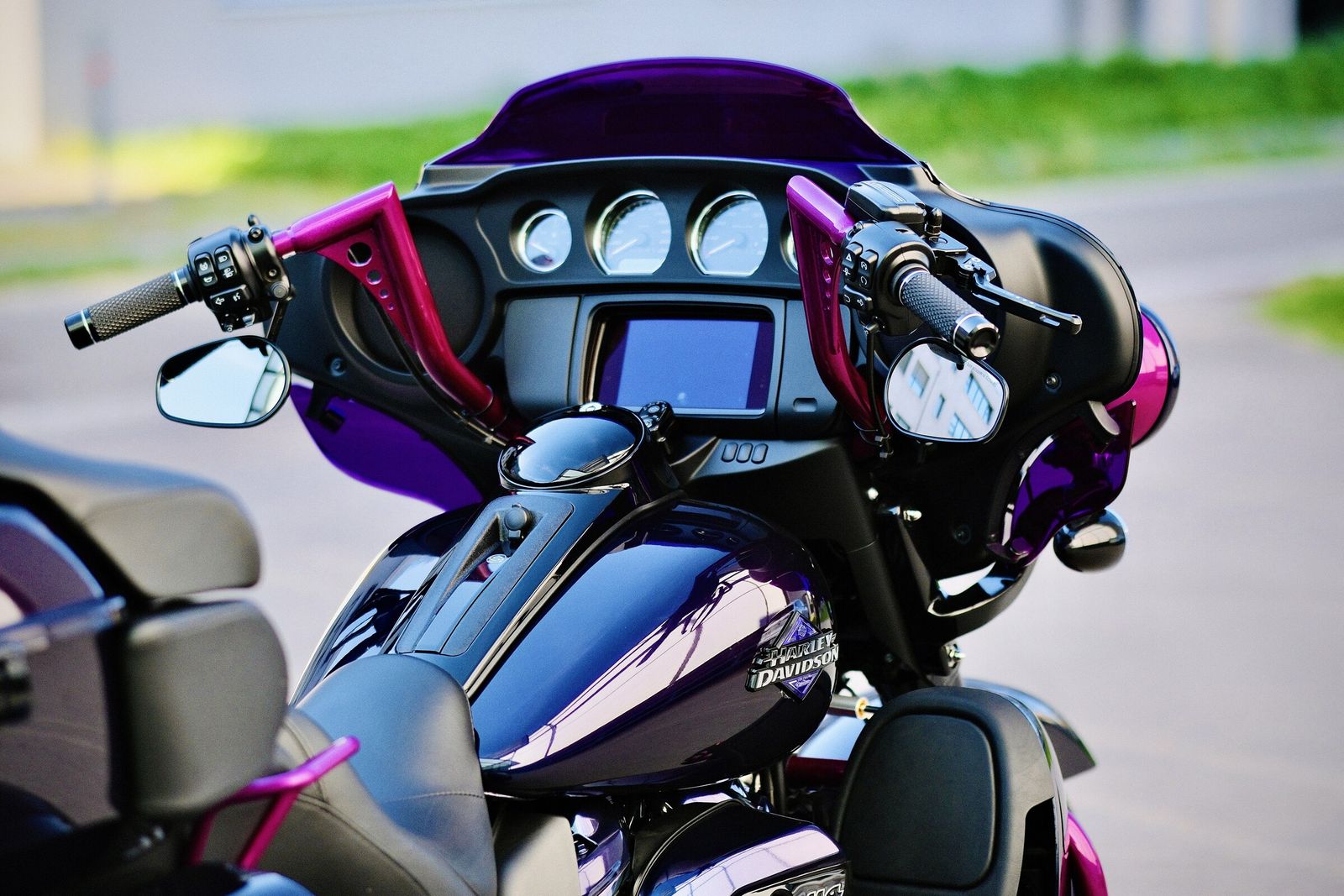Blick von schräg hinten über die Sitzbank auf die Armaturen eines Harley-Davidson Trikes, Verkleidung in Blauviolett mit Akzenten in Magenta