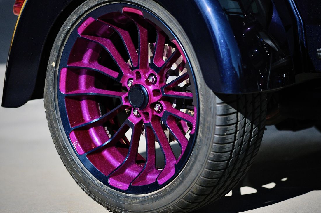 Hinterrad des Trikes mit Felge in Magenta und schwarzem Felgenrand