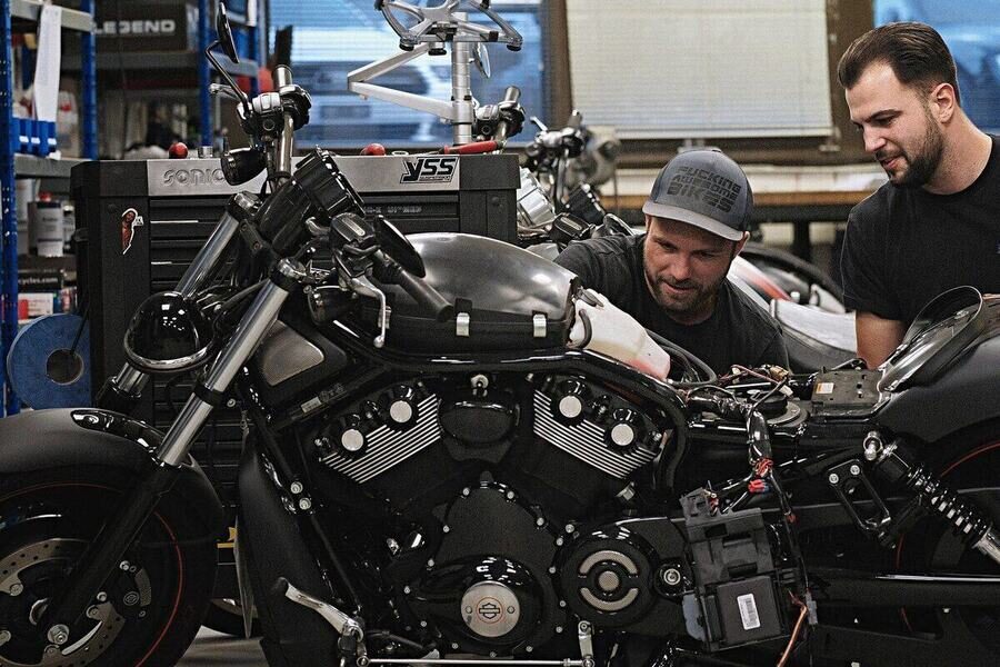 Zwei Mechaniker arbeiten in der Werkstatt an einer Harley-Davidson V-Rod